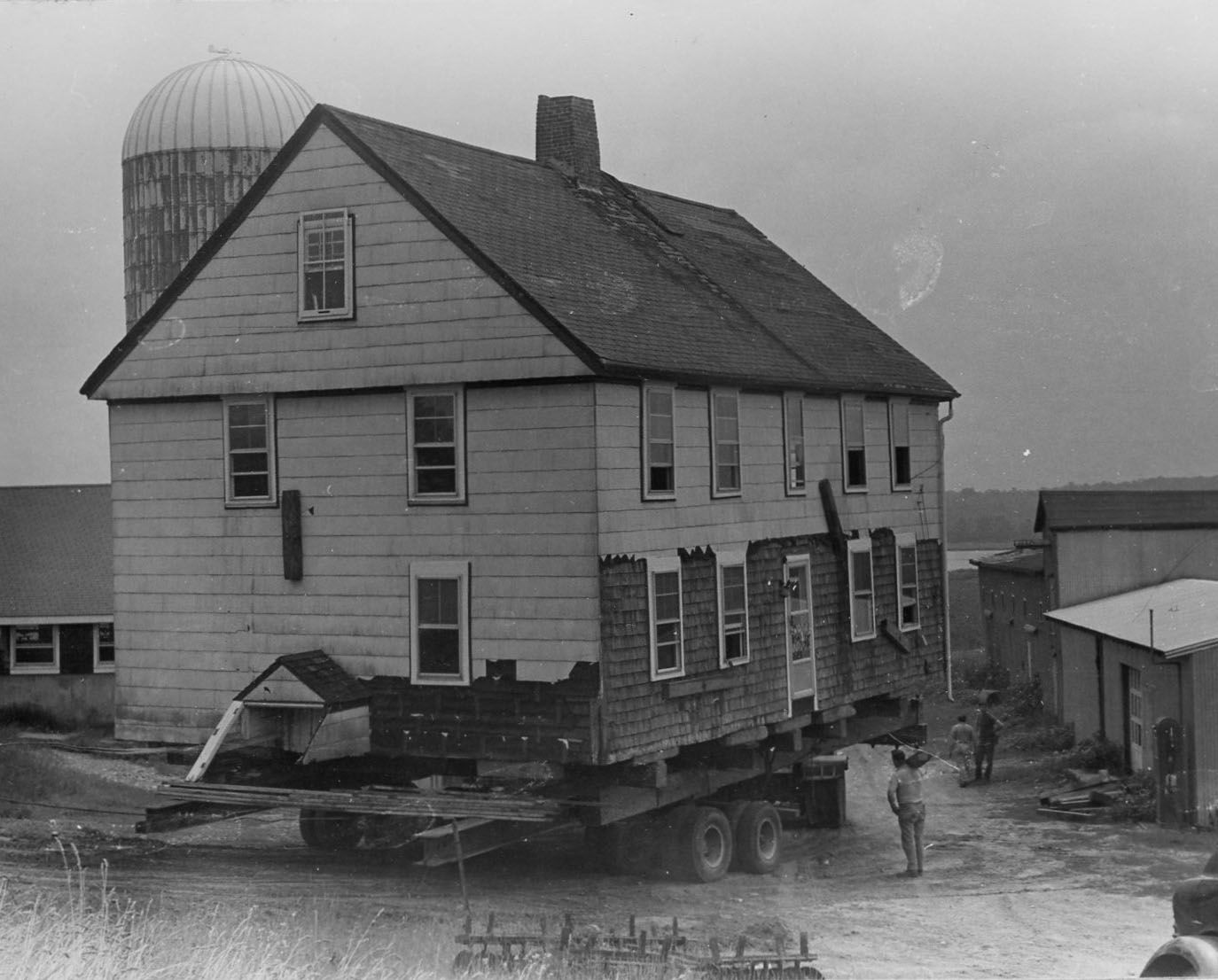 Moving the Tripp House down from the hill, into the barnyard and through the field to its new location.