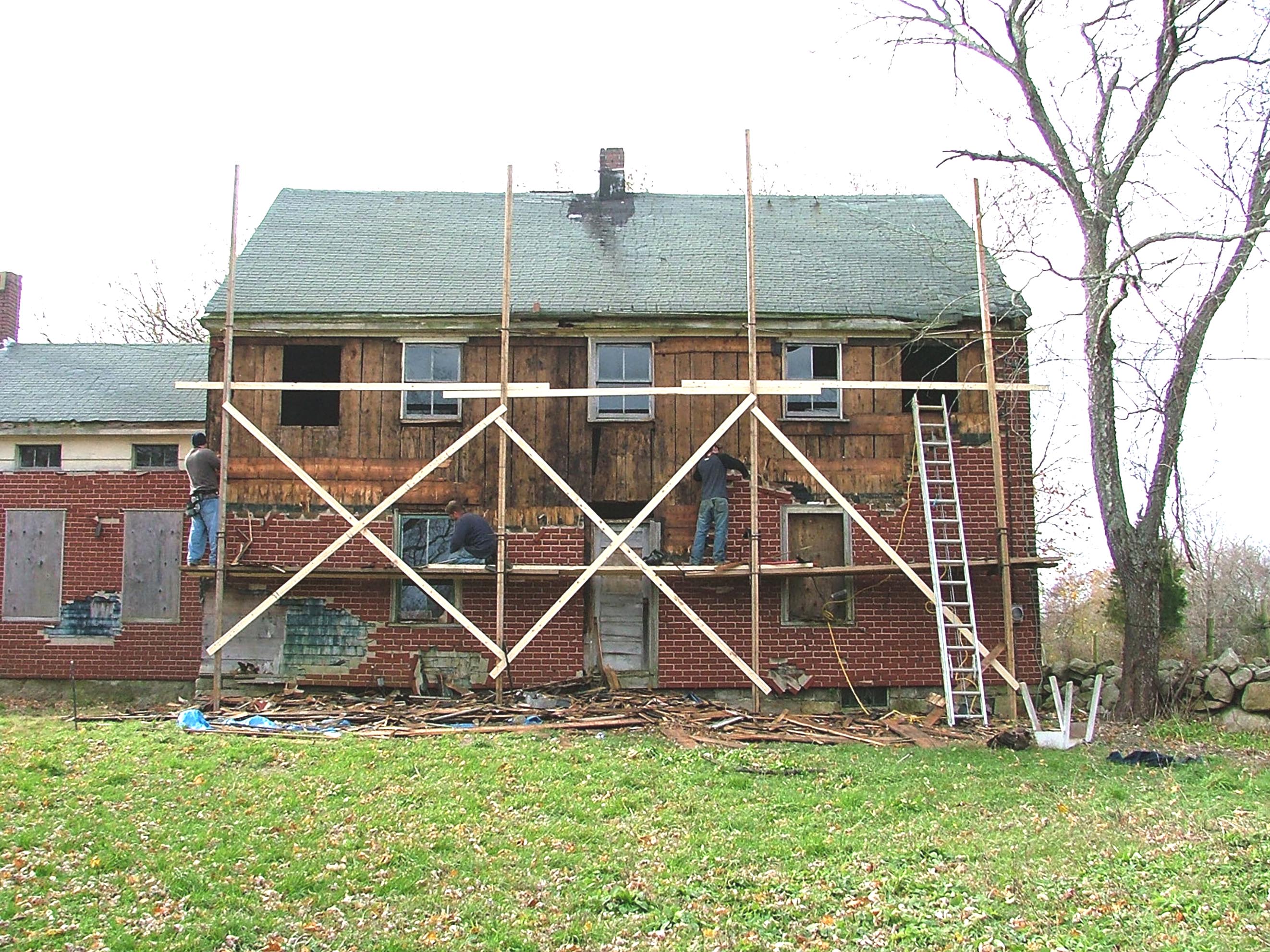 Removing faux brick siding from the front of Cory House